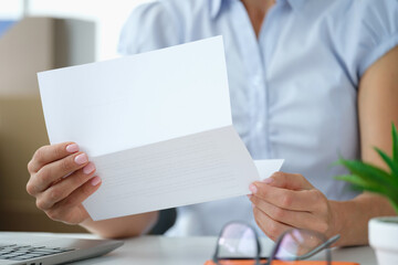 Woman holding envelope with paper letter or invitation inside