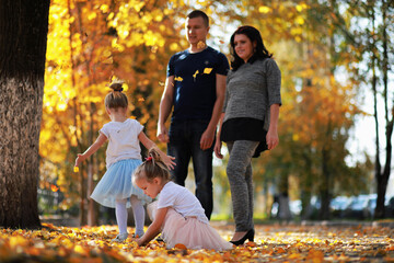 Leaf fall in the park. Children for a walk in the autumn park. Family. Fall. Happiness.