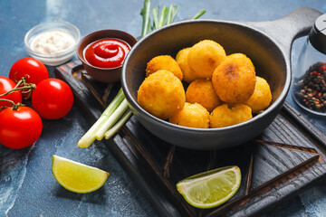 Composition with fried potato balls on color background