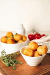 Bowl with fried potato balls on table