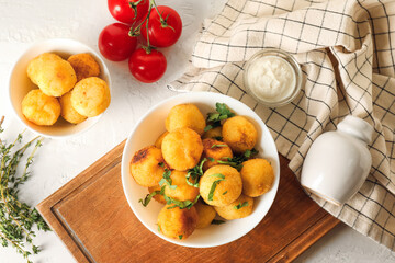 Composition with fried potato balls on light background