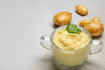 Pot with tasty mashed potatoes on light background