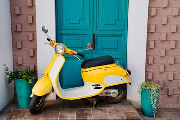 Raamstickers yellow motorcycle at the turquoise wooden door © andrey