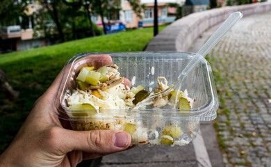 Turkish Tavuk Pilav in a plastic cup - a famous street food made of chicken and rice garnished with salad and pickles - Street Food in park concept