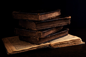 Stack of old worn shabby jewish books in leather binding on the open pages of Machzor in the dark....