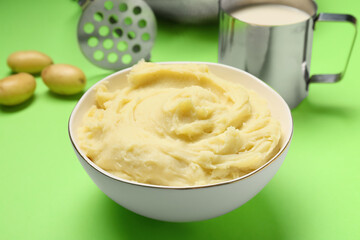 Bowl with tasty mashed potatoes on color background