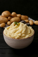 Fototapeta na wymiar Bowl with tasty mashed potatoes on dark wooden background