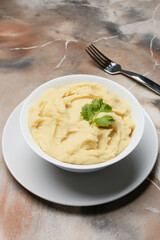 Bowl with tasty mashed potatoes on grunge background