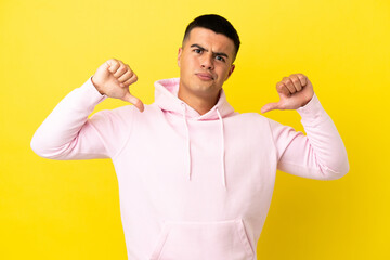 Young handsome man over isolated yellow background proud and self-satisfied