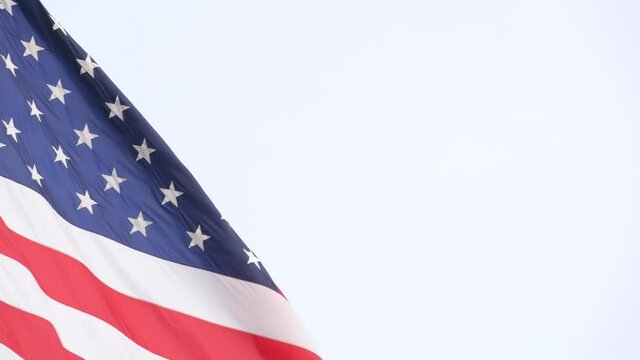 American flag waving in wind, USA. National symbol waves in breeze on flagpole. Real Old Glory Star Spangled Banner as concept of independence, liberty, democracy, patriotism. Background for 4th July.