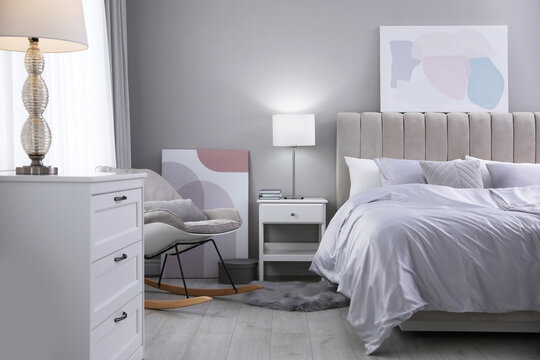 Cozy bed with soft silky bedclothes in light room