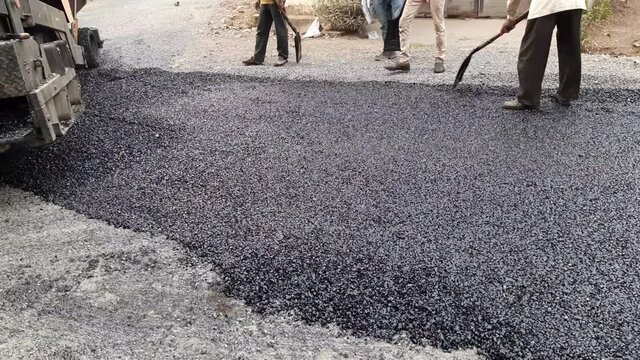 Workers making asphalt new road construction site with shovel construction and repairing. Making new asphalt at road construction. Paver or paving machine lay bitumen. Rollers