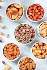 Nuts in bowls, shot from the top on a slate background. Pistachios, almonds, walnuts and other nuts