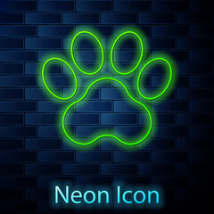 Glowing neon line Paw print icon isolated on brick wall background. Dog or cat paw print. Animal track. Vector © vector_v