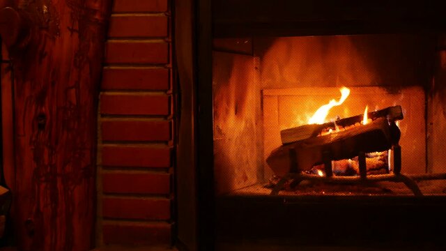 Fire in brick fireplace, firewood burning, wood blazing in cozy lodge, hut or cabin. Romantic weekend on winter holidays, fireside in warm cosy cottage house. Seamless looped cinemagraph background.