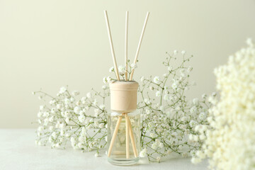 Diffuser and flowers on white textured table