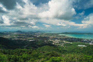 Top view of the city on a tropical island surrounded by green hills and the sea, cloudy weather. Summer vacation and nature travel adventure concept.. Summer composition.