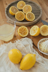 Fresh lemonade in the making: fresh lemons, lemon juice and juicer close up.