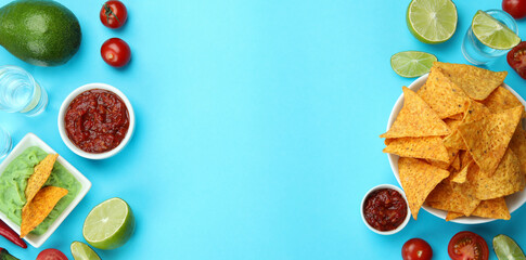 Party concept with tequila, guacamole and chips on blue background