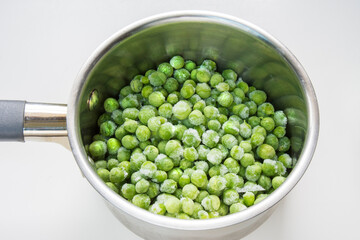Frozen green peas in a pot to boil