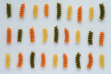 Tricolore fusilli italian pasta on white background.