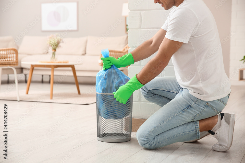 Sticker man taking garbage bag out of bin at home, closeup