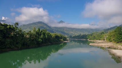 Fototapeta na wymiar Scenic panorama view of the Subansiri river valley with mountain background and low morning clouds in Daporijo, Arunachal Pradesh, India