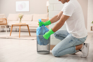 Man taking garbage bag out of bin at home, closeup