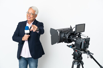 Reporter Middle age Brazilian man holding a microphone and reporting news isolated on white background pointing front with happy expression