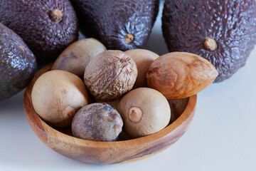 Obraz premium Avocado seed in a wooden bowl on white background, for medicinal use