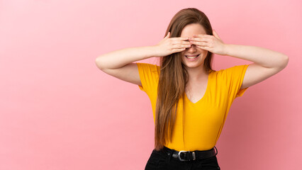 Teenager girl over isolated pink background covering eyes by hands and smiling