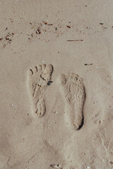 Two Footprints in sand at the Beach