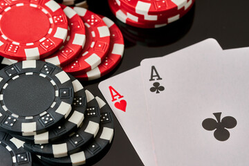 Casino chips and playing cards on dark reflective background