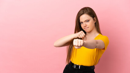 Teenager girl over isolated pink background with fighting gesture