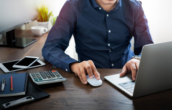 image of Businessman using mouse computer and typing keyboard of laptop computer notebook on office desk. Workspace, working project for job online network. Business finance and technology concept.