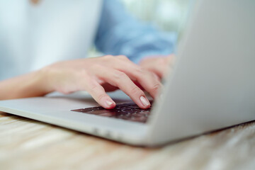 Close Up Asian woman's hand pressing her finger on the keyboard of a notebook computer.