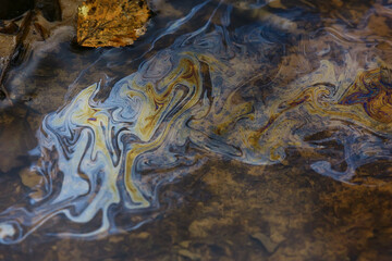 oil spills on puddle background, abstract gasoline nature pollution concept