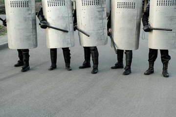 Obraz premium Police force walking with shields over street