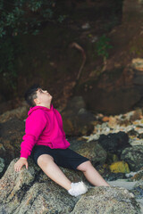 Niño sentado en la roca en una playa escondida de Galicia