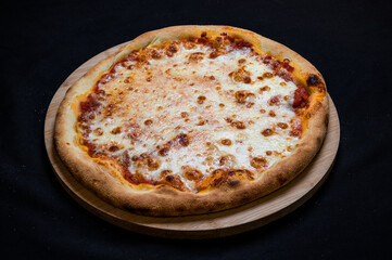 Pizza with tomato sauce and mozzarella cheese on a black background.