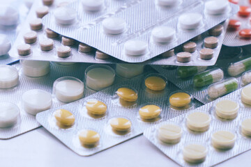 Overall view of pharmaceutical tablets and capsules in packages in assortment. Tablets in a blister
