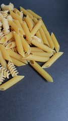 different noodles on black background