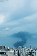 huge explosion and fire at plastic factory on outskirts of town, thick black smoke filled sky over city after explosion at chemical manufacturer, environmental pollution concept