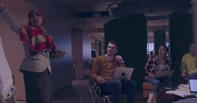 Businesswoman in wheelchair having business meeting with team at modern office 