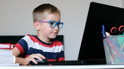 Online learning, distance lesson, education at home. Cute Boy in glasses doing homework at home