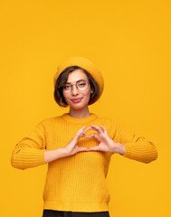 Stylish woman showing heart gesture