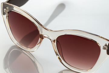 Sunglasses on a white reflective surface. Fashionable, stylish accessories. Use it for a vacation...