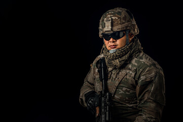 Photo of soldier in black background. Special forces United States soldier or private military contractors holding rifle. Image on black background. soldier, army, war, weapon and technology concept.