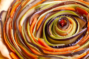 Process of cooking vegetable spiral tart with zucchini, eggplant, carrots, bell pepper, basil in silicone baking dish - obrazy, fototapety, plakaty