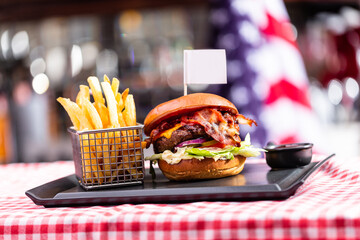 Burger with empty food flag and french fries in american restaurant. - obrazy, fototapety, plakaty